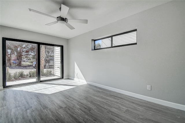 unfurnished room with wood finished floors, baseboards, and a wealth of natural light