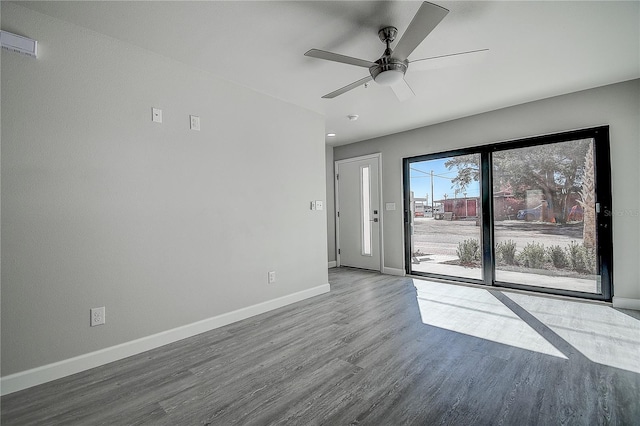 empty room featuring wood finished floors, ceiling fan, and baseboards