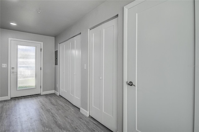 doorway featuring electric panel, recessed lighting, baseboards, and wood finished floors
