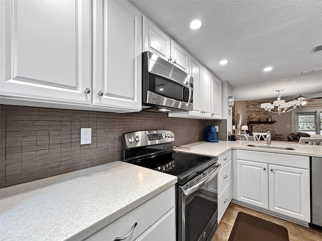 7508 Hollowell Dr, Tampa, FL 33615 - kitchen featuring light countertops, appliances with stainless steel finishes, a sink, and white cabinets