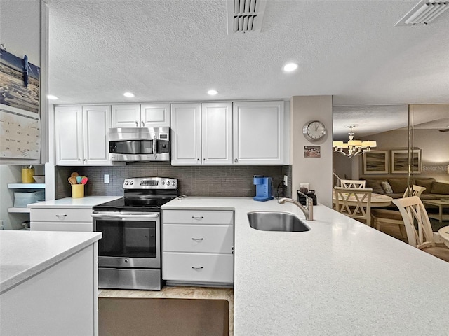 7508 Hollowell Dr, Tampa, FL 33615 - kitchen with light countertops, a sink, visible vents, and stainless steel appliances