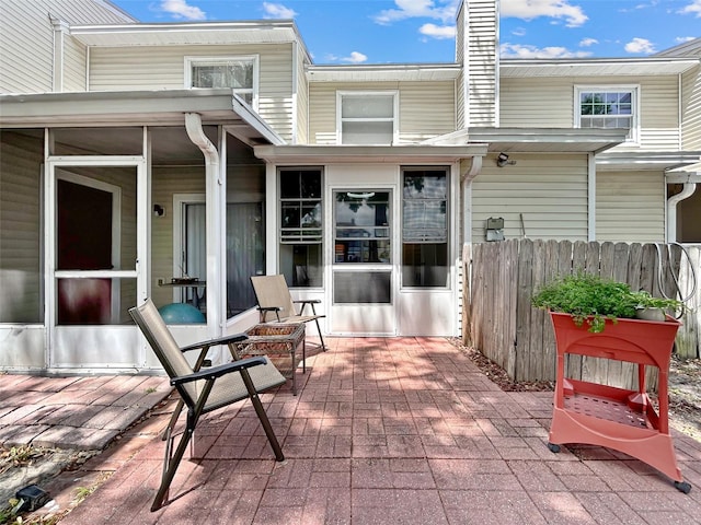 7508 Hollowell Dr, Tampa, FL 33615 - back of property featuring a patio, a sunroom, fence, and a chimney