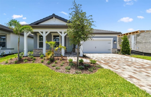 10317 Cross River Trl, Parrish, FL 34219 - view of front of property featuring a garage, stucco siding, a front yard, covered porch, and stone siding