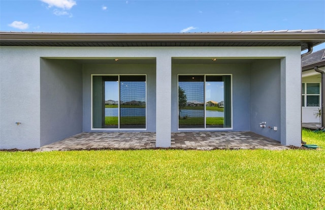 10317 Cross River Trl, Parrish, FL 34219 - back of property with stucco siding, a lawn, and a patio area
