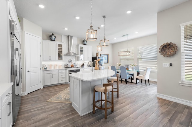 4365 Frontera Ln, Wesley Chapel, FL 33543 - kitchen with a kitchen bar, wall chimney range hood, decorative backsplash, and wood finished floors