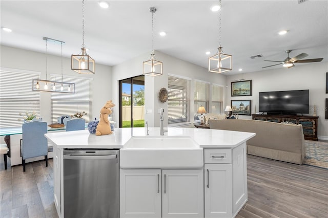 4365 Frontera Ln, Wesley Chapel, FL 33543 - kitchen with stainless steel dishwasher, a sink, open floor plan, visible vents, and light countertops