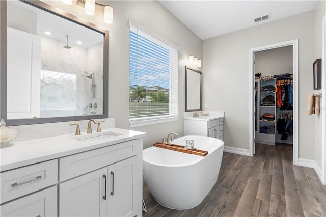 4365 Frontera Ln, Wesley Chapel, FL 33543 - full bath with a tile shower, wood finished floors, a sink, and visible vents