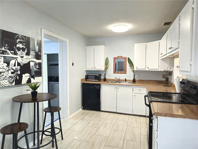 3545 7th Ave N, Saint Petersburg, FL 33713 - kitchen with a sink, white cabinetry, black appliances, and dark countertops