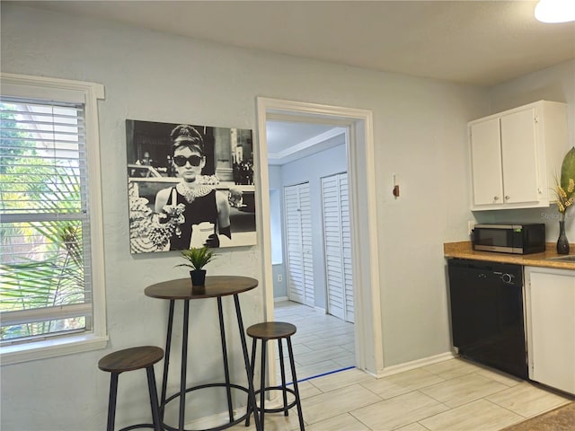 3545 7th Ave N, Saint Petersburg, FL 33713 - kitchen featuring stainless steel microwave, baseboards, white cabinetry, black dishwasher, and wood tiled floor