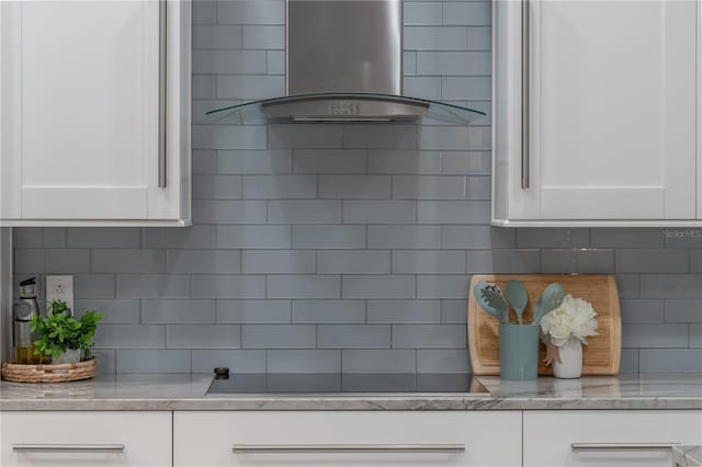 1084 Berkshire Ln, Tarpon Springs, FL 34688 - kitchen view of island exhaust hood, backsplash, white cabinets, and black electric cooktop
