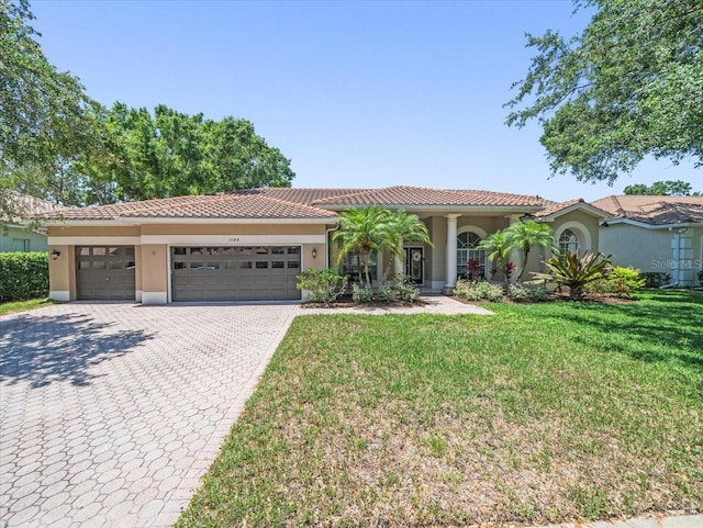 1084 Berkshire Ln, Tarpon Springs, FL 34688 - mediterranean / spanish-style home featuring stucco siding, decorative driveway, a front yard, an attached garage, and a tile roof