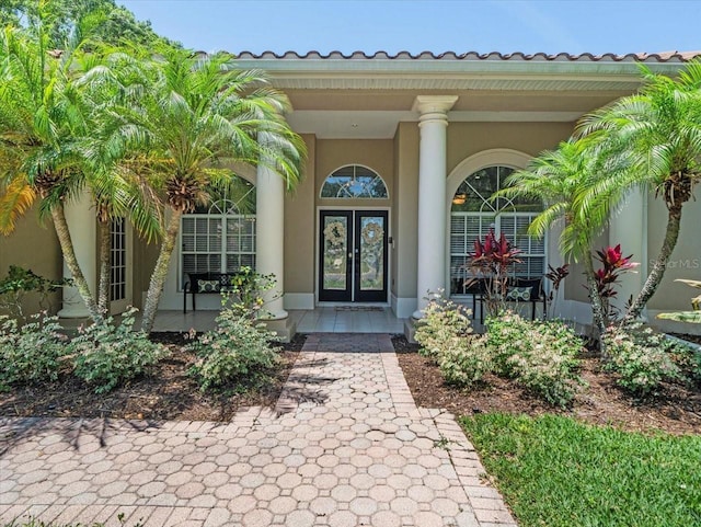 1084 Berkshire Ln, Tarpon Springs, FL 34688 - entrance to property with a porch, french doors, and stucco siding