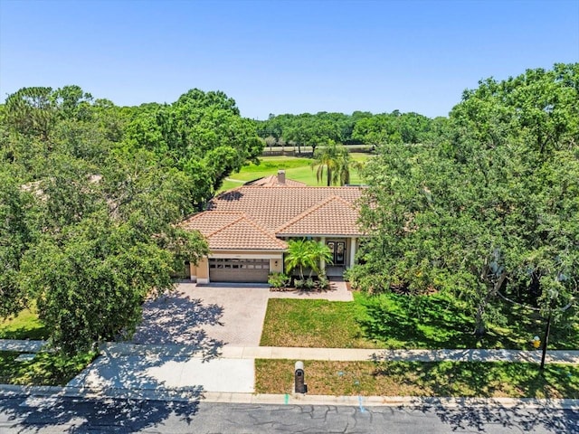 1084 Berkshire Ln, Tarpon Springs, FL 34688 - view of front of house featuring an attached garage, a tile roof, driveway, stucco siding, and a front lawn