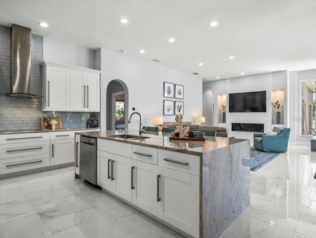 1084 Berkshire Ln, Tarpon Springs, FL 34688 - kitchen featuring arched walkways, wall chimney exhaust hood, a sink, light marble finish floors, and stainless steel dishwasher