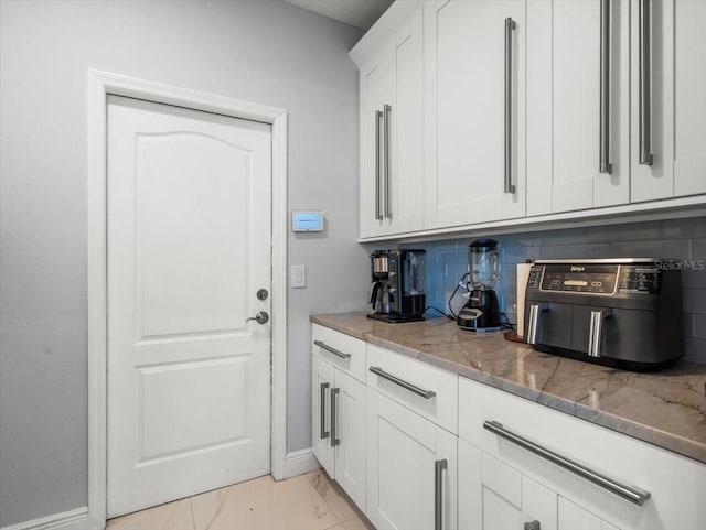 1084 Berkshire Ln, Tarpon Springs, FL 34688 - laundry room featuring light marble finish floors and baseboards