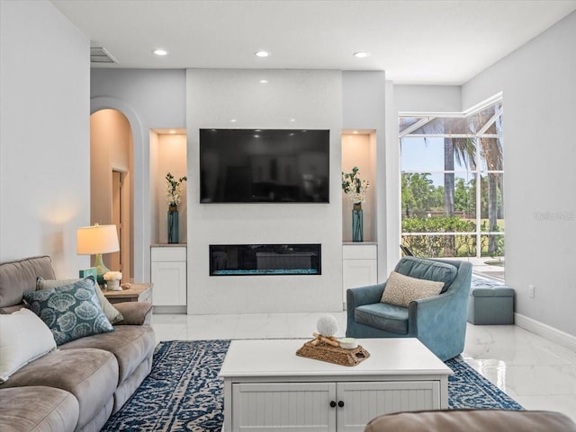1084 Berkshire Ln, Tarpon Springs, FL 34688 - living area featuring marble finish floors, a glass covered fireplace, recessed lighting, baseboards, and arched walkways