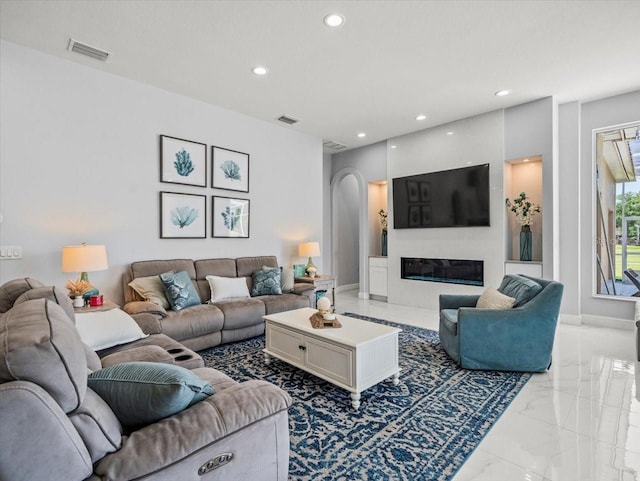 1084 Berkshire Ln, Tarpon Springs, FL 34688 - living room with light marble finish flooring, recessed lighting, arched walkways, and a glass covered fireplace