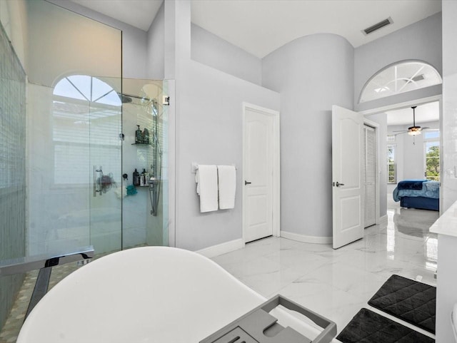 1084 Berkshire Ln, Tarpon Springs, FL 34688 - full bathroom featuring a stall shower, connected bathroom, ceiling fan, a towering ceiling, and marble tiled flooring