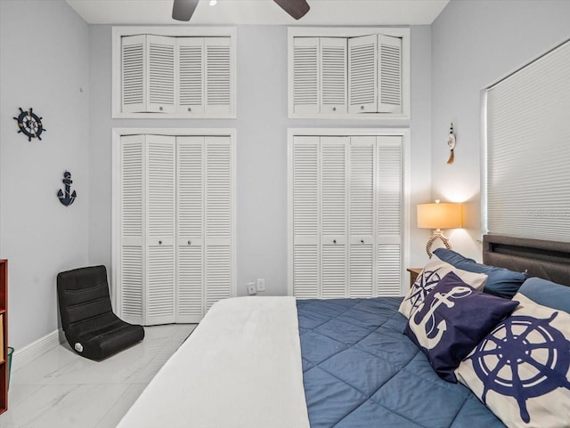 1084 Berkshire Ln, Tarpon Springs, FL 34688 - bedroom featuring marble finish floors, two closets, baseboards, ceiling fan, and a high ceiling