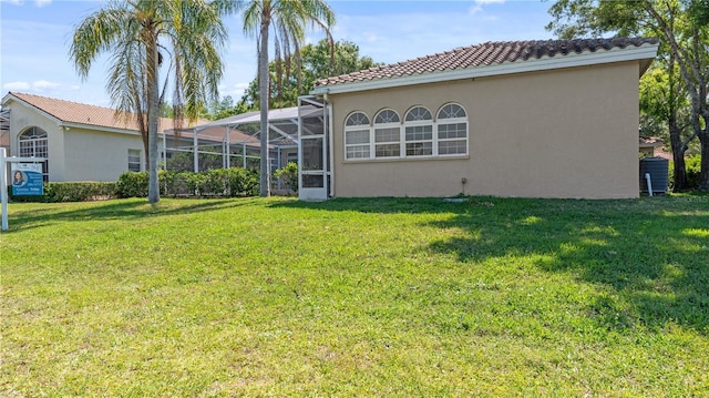 1084 Berkshire Ln, Tarpon Springs, FL 34688 - back of house featuring a yard, stucco siding, a tile roof, and a lanai