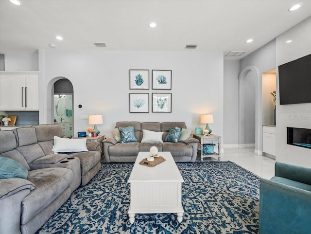 1084 Berkshire Ln, Tarpon Springs, FL 34688 - living room with arched walkways, recessed lighting, a glass covered fireplace, and marble finish flooring