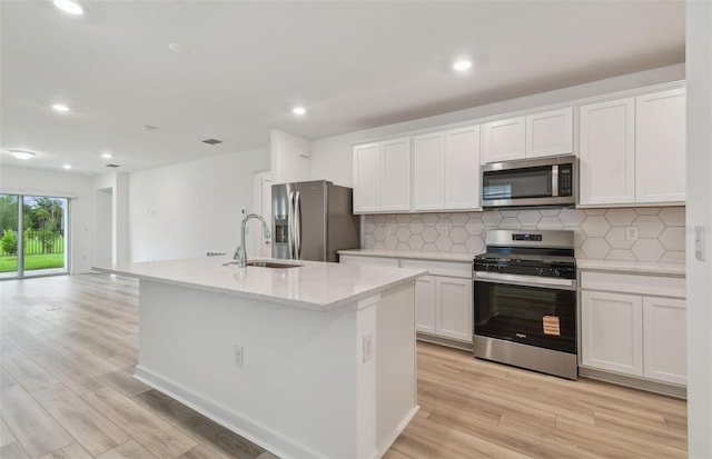 10414 Cross River Trl, Parrish, FL 34219 - kitchen with stainless steel appliances, light wood-style floors, tasteful backsplash, white cabinets, and recessed lighting