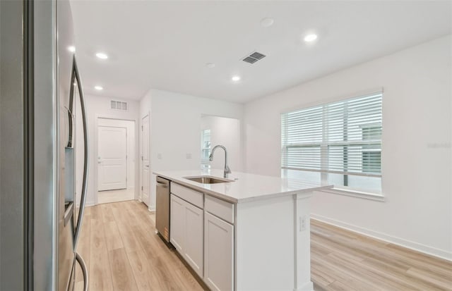 10414 Cross River Trl, Parrish, FL 34219 - kitchen featuring appliances with stainless steel finishes, light wood-style flooring, a center island with sink, and recessed lighting
