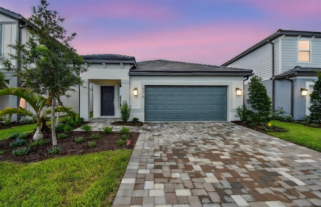 10414 Cross River Trl, Parrish, FL 34219 - view of front of home featuring decorative driveway, an attached garage, stucco siding, and a tiled roof
