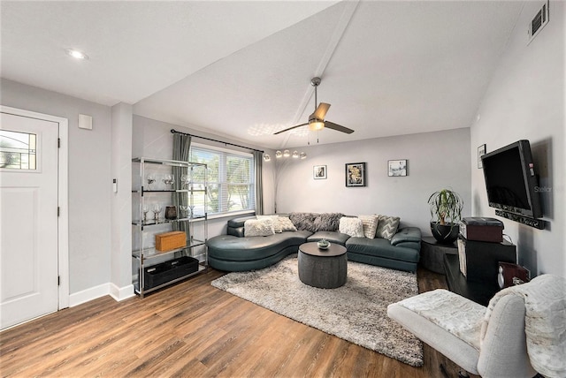 living area featuring a ceiling fan, visible vents, wood finished floors, and baseboards