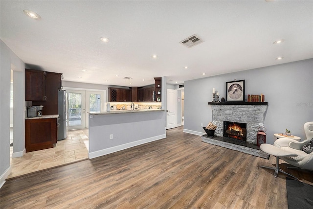 living area featuring baseboards, visible vents, and a fireplace