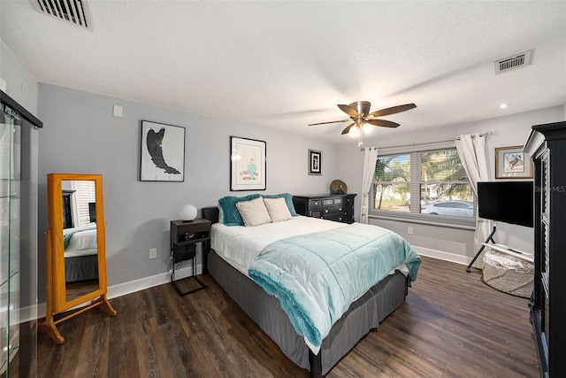 bedroom with baseboards, visible vents, a textured ceiling, and dark wood-style flooring