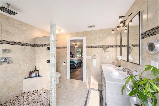ensuite bathroom with tile walls, visible vents, and a sink