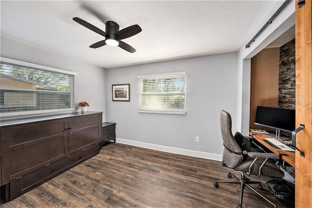 office with dark wood-style floors, a ceiling fan, and a healthy amount of sunlight