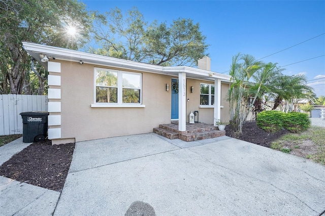 single story home with a chimney, fence, stucco siding, and a patio