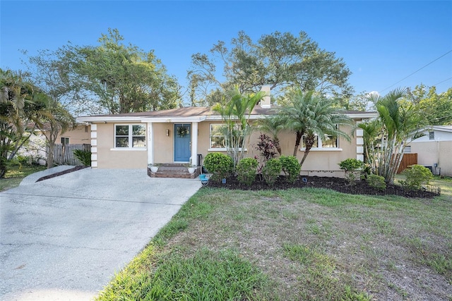 single story home with concrete driveway, a front lawn, stucco siding, and fence