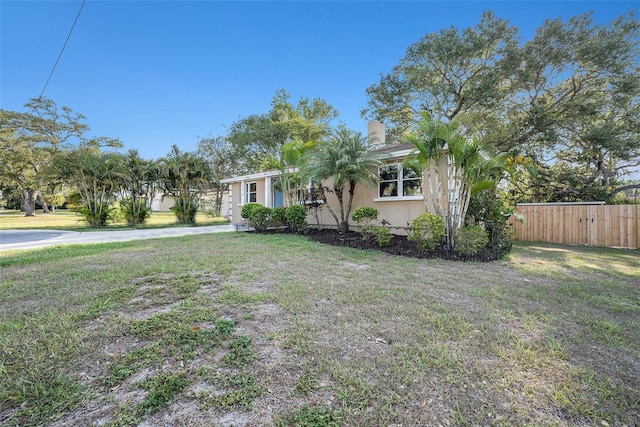 ranch-style house with a front yard, stucco siding, and fence