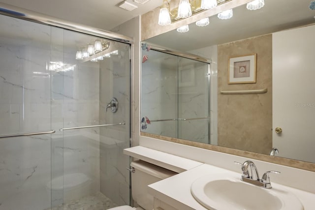 full bath with a shower stall, vanity, visible vents, and toilet