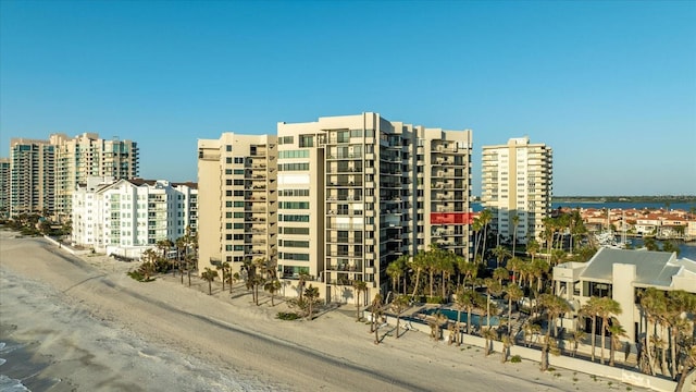 view of building exterior featuring a water view, a view of city, and a view of the beach