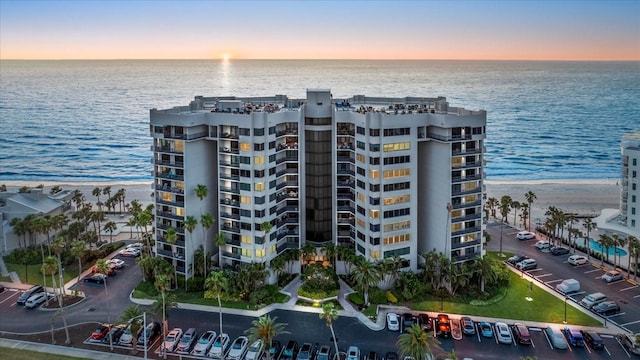 property at dusk with a water view