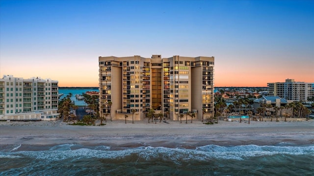 view of building exterior featuring a water view and a view of the beach