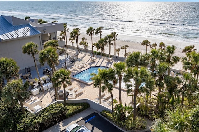 birds eye view of property with a water view and a beach view