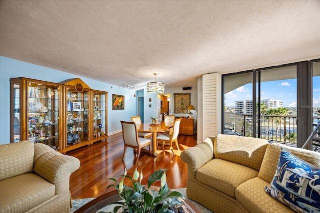 living area featuring a textured ceiling, baseboards, and wood finished floors