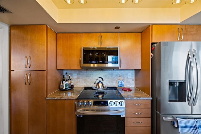 kitchen featuring stainless steel appliances, tasteful backsplash, and brown cabinets