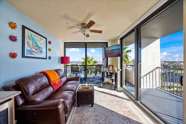 living room featuring a wall of windows and a ceiling fan