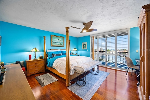 bedroom featuring ceiling fan, access to outside, wood finished floors, and a textured ceiling