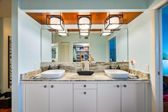full bathroom featuring a sink, double vanity, and wood ceiling
