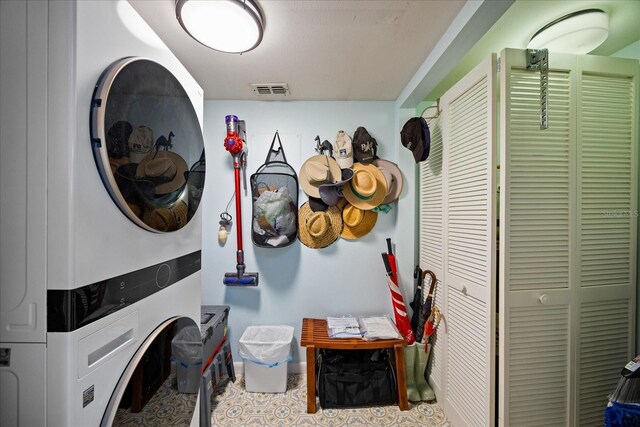 laundry area featuring laundry area, stacked washer and clothes dryer, and visible vents