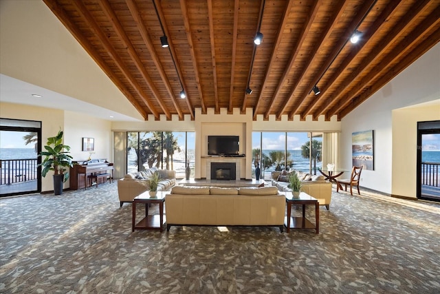 carpeted living area with high vaulted ceiling, a tiled fireplace, wood ceiling, and beam ceiling
