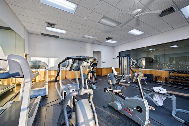 gym with visible vents, a ceiling fan, and a drop ceiling