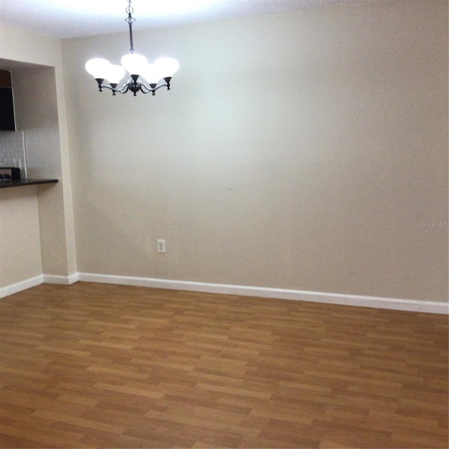 2625 State Road 590 Unit 1822, Clearwater, FL 33759 - spare room featuring baseboards, a chandelier, and wood finished floors